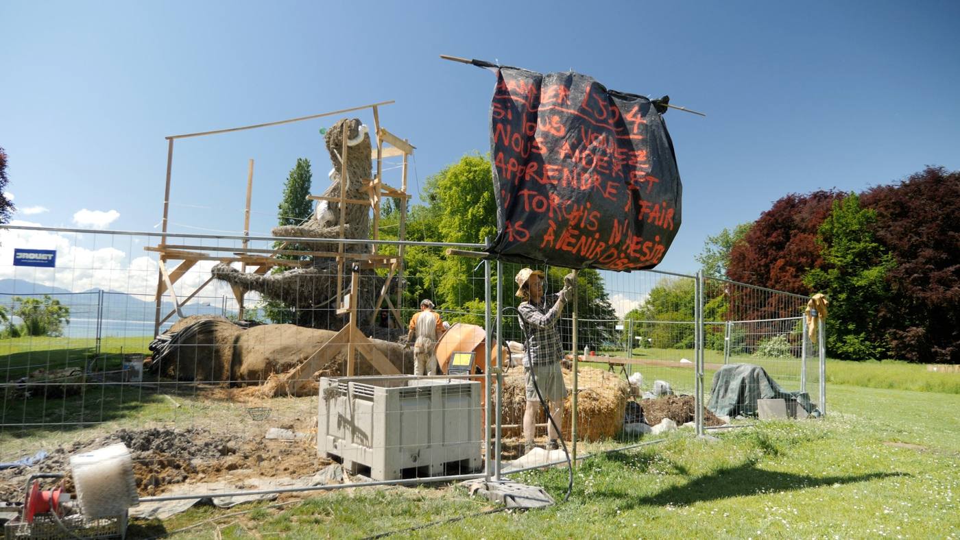 Construction d’une sculpture en torchis derrière les barrières de chantier