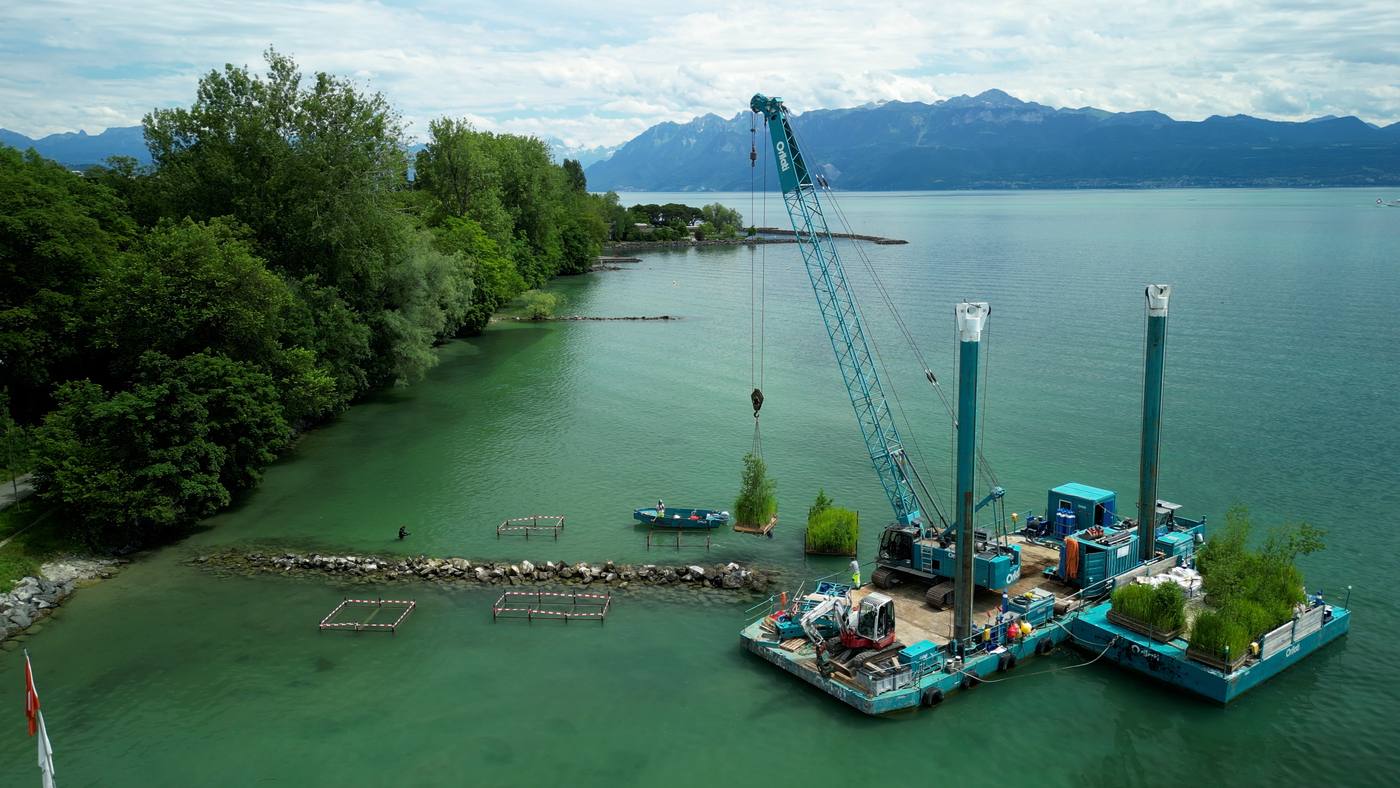 Vue aérienne d’une barge et d’une grue posant les îles sur le lac