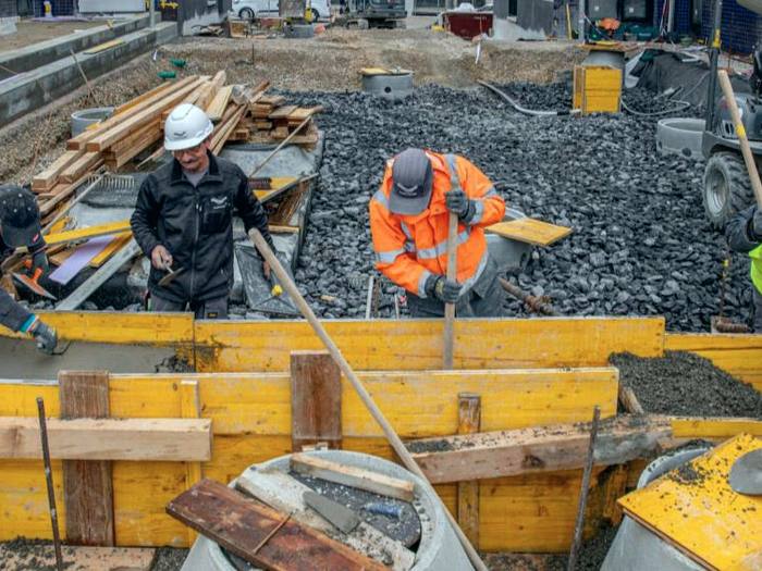Ouvriers coulant du béton dans les coffrages des gradins
