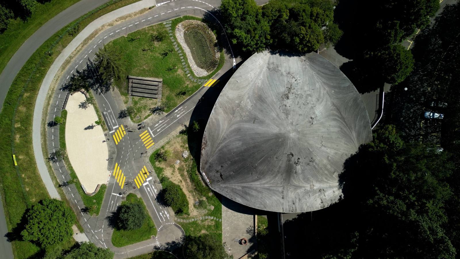 Vue aérienne après travaux : étang, pelouses et stabilisé