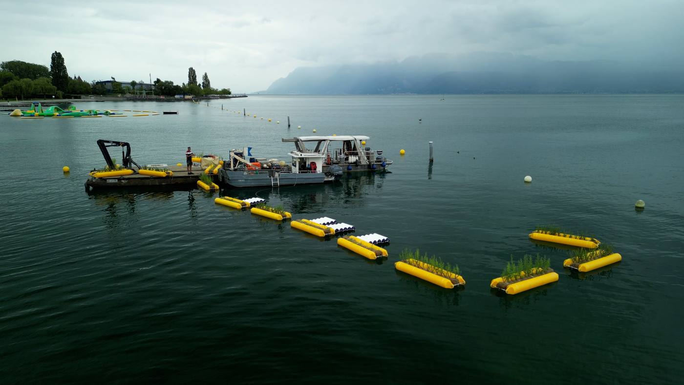 Bateaux remorquant les flotteurs jaunes du bassin sur le lac