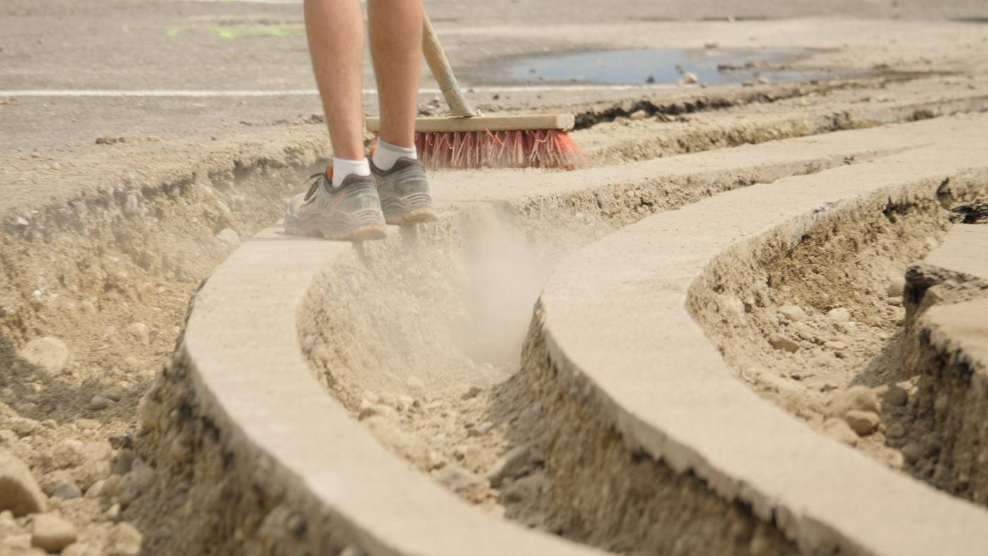 Courbes de sable balayées sur l’asphalte